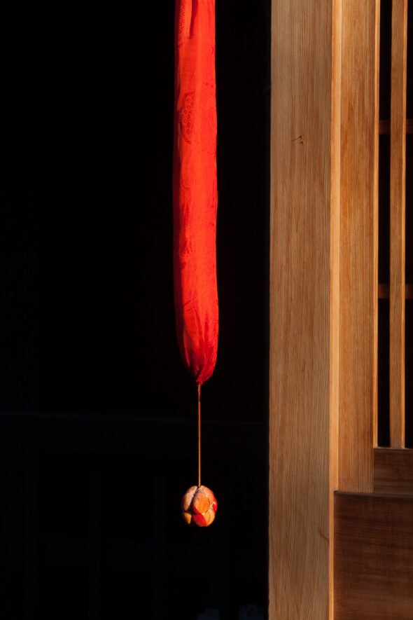 A bright red door tassle in Japan with black background