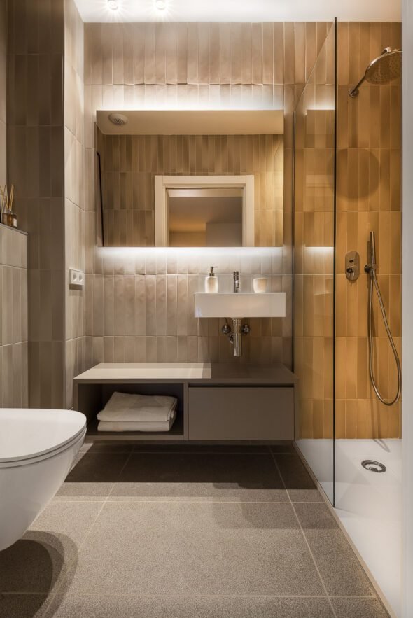 hotel shower room tiled in gold with Led lighting barcelona