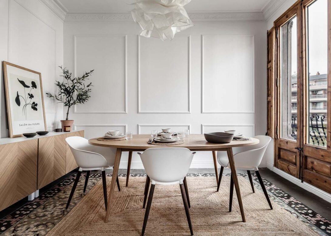 Beautiful dining area styled in wood featuring a wood dining table, white chairs, clay dining set, wooden modern cabinet french stripped wood door by interior designer