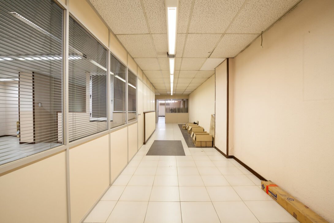 commercial office corrider with empty boxes on the floor strip lighting and metal blinds