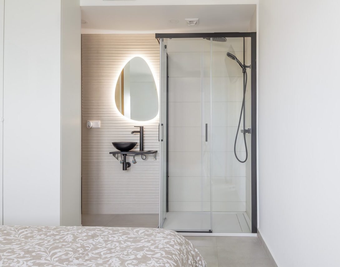 Open ensuite bedroom in white and beige residential apartment