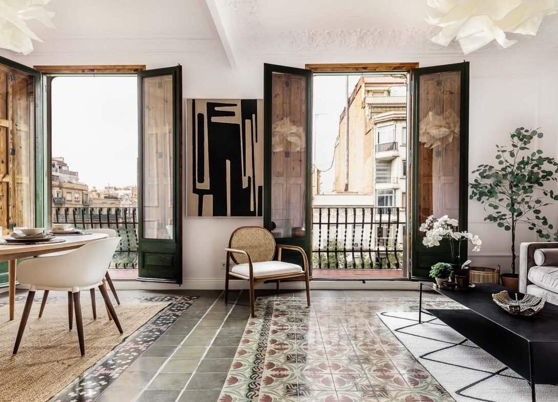 Modernist living room in a finca regia building with original mosaic hydrolic floor tiles and contemporary modern furniture in dark brow and green hues in barcelona