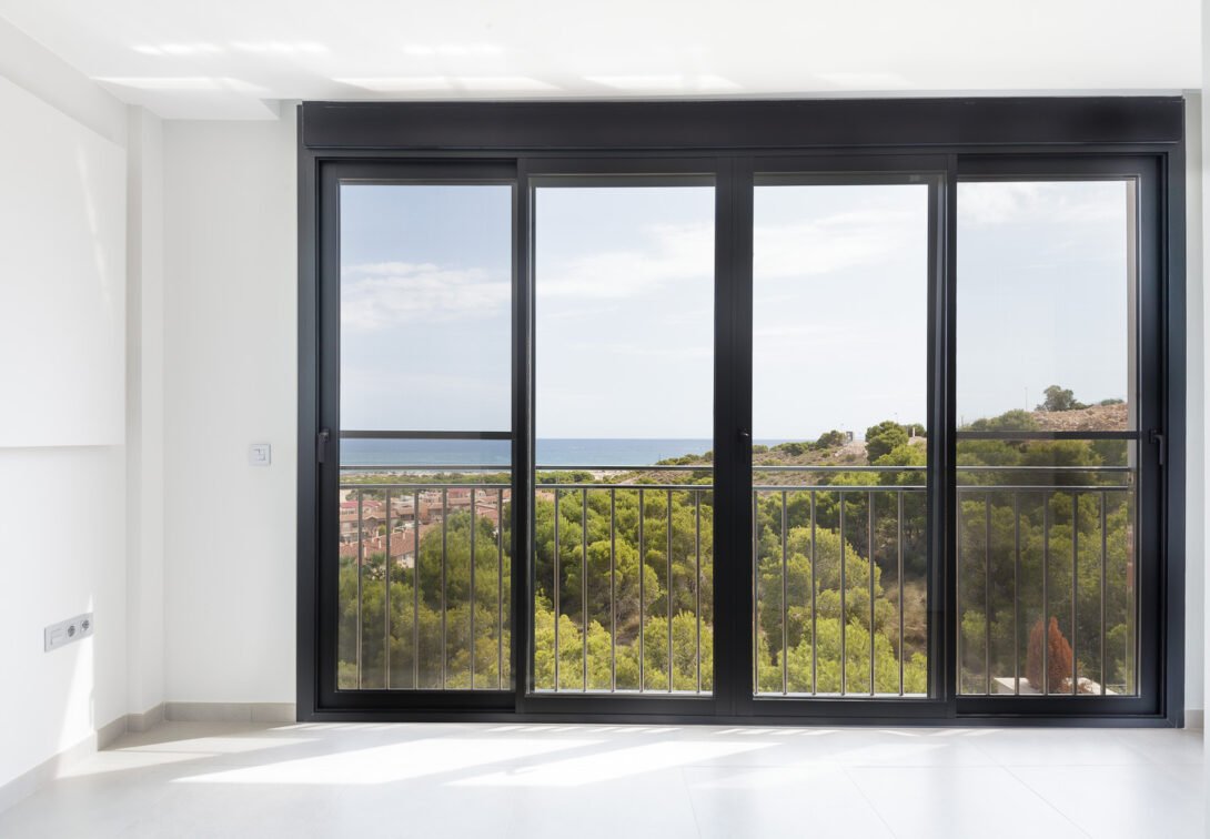 Large bay window with golden light and view to forest and the sea