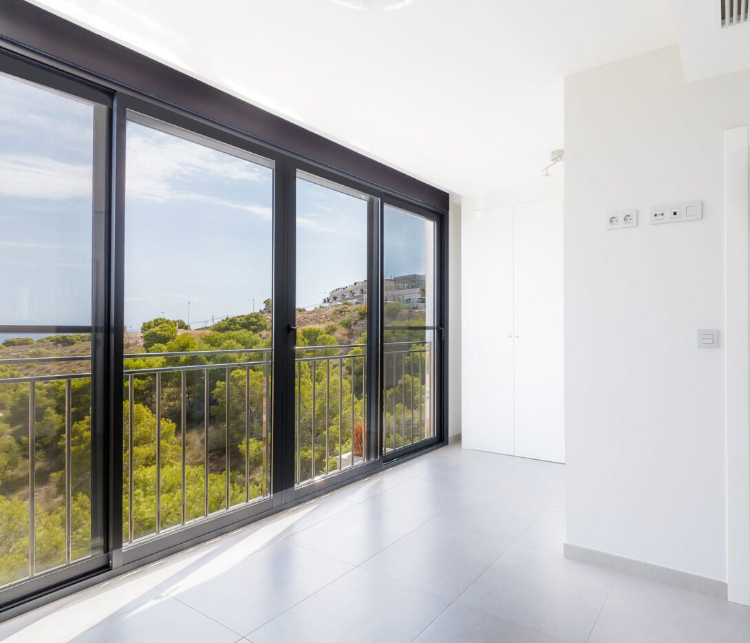 side angle of empty bedroom and view to the wild forest and beach