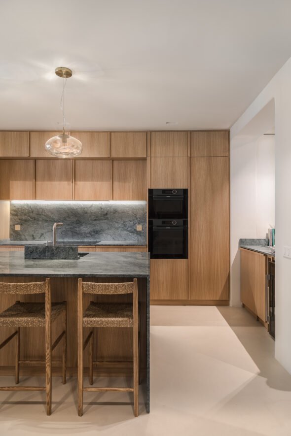 A kitchen design using natural wood and marble to compliment each other in a residential home in Barcelona