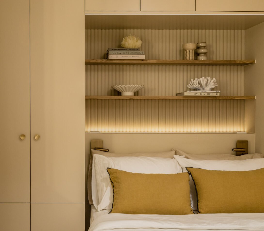 cosy contemporary bedroom with bed encased shelving warm lightiing and warm yellow hues