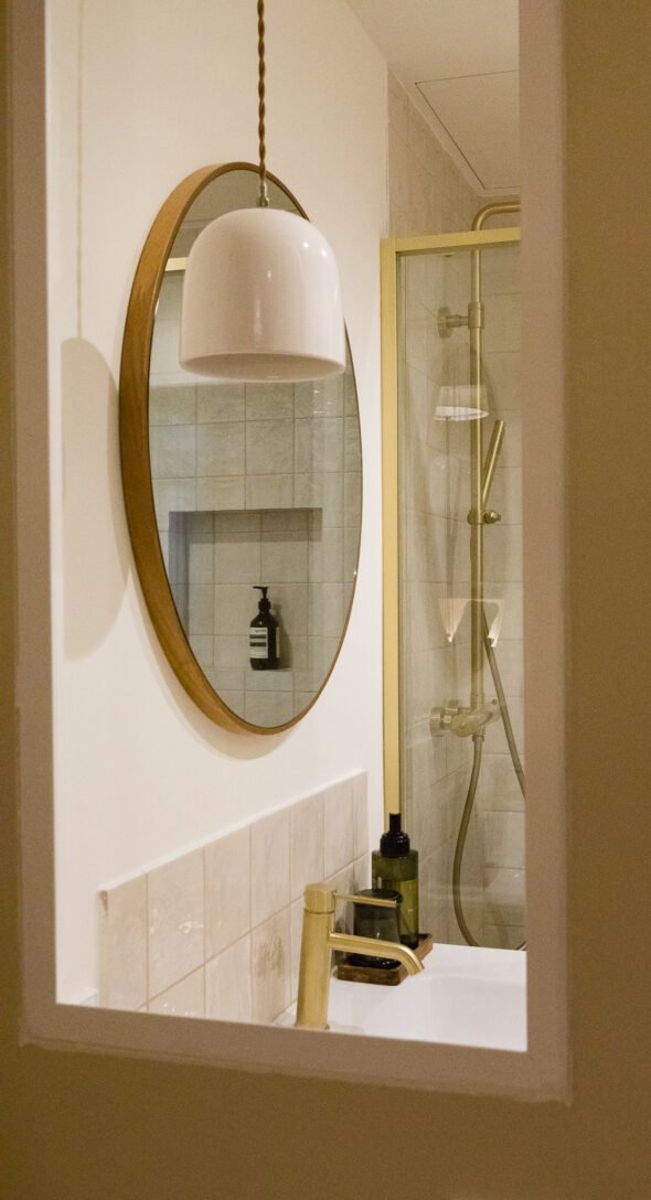 a glass window peering into a modern take on a vintage bathroom
