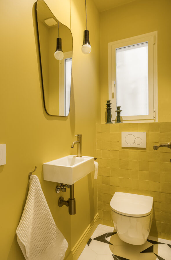 A small bathroom in Babouche yellow and black and white tiled floor. Senillosa apartment in Sant Gervasi Barcelona